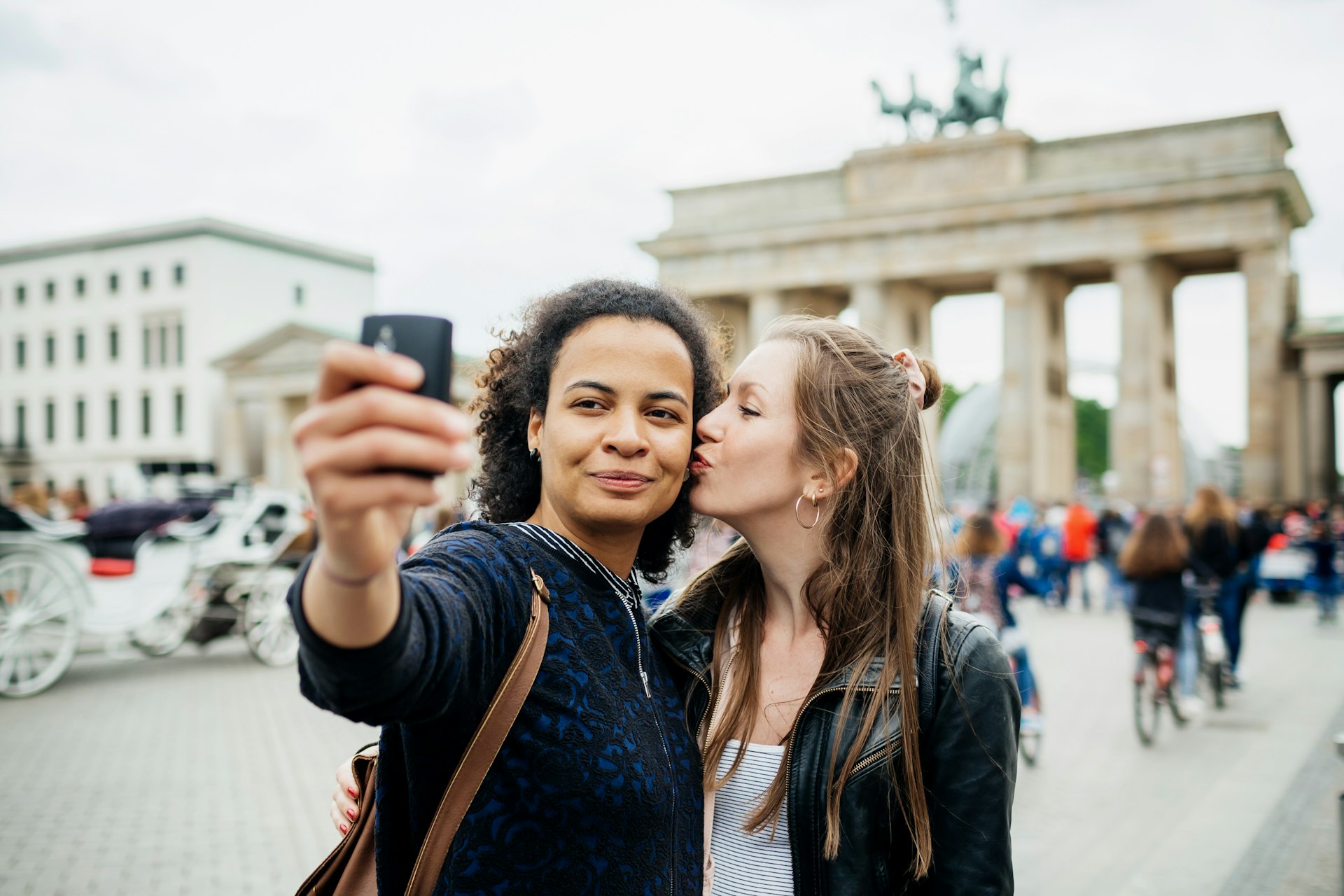 Young lesbian Couple Stop To Take A Selfie At Brandenburg Gate in Berlin